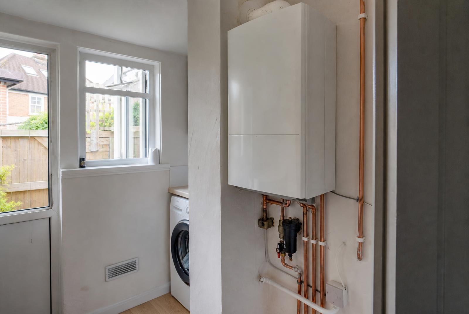 Newly installed combi boiler with neat copper pipework and magnetic filter in a Chesterfield utility room