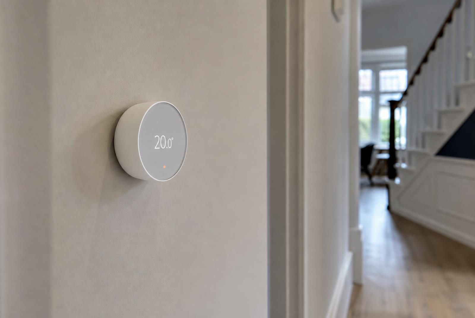 Smart heating thermostat showing 20 degrees on a hallway wall of a Dronfield home